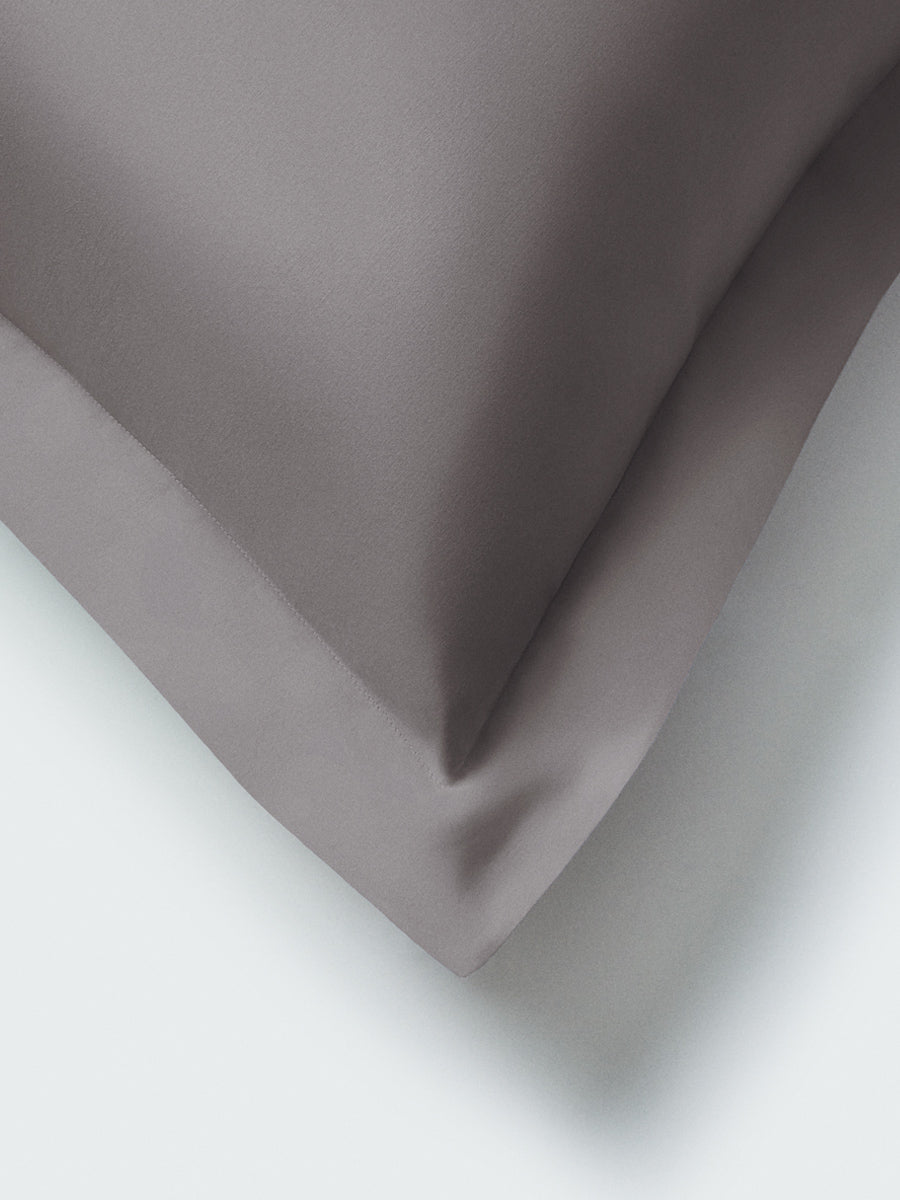 Part of a pillow with a Hampshire Charcoal color pillowcase featuring embroidery along the edge.