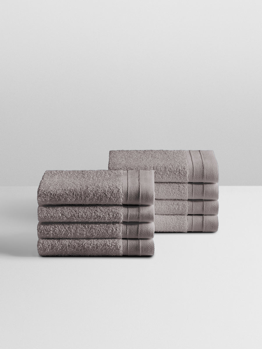 A stack of eight soft, “Hampshire Charcoal” colored bath wash clothes neatly folded on a white surface.