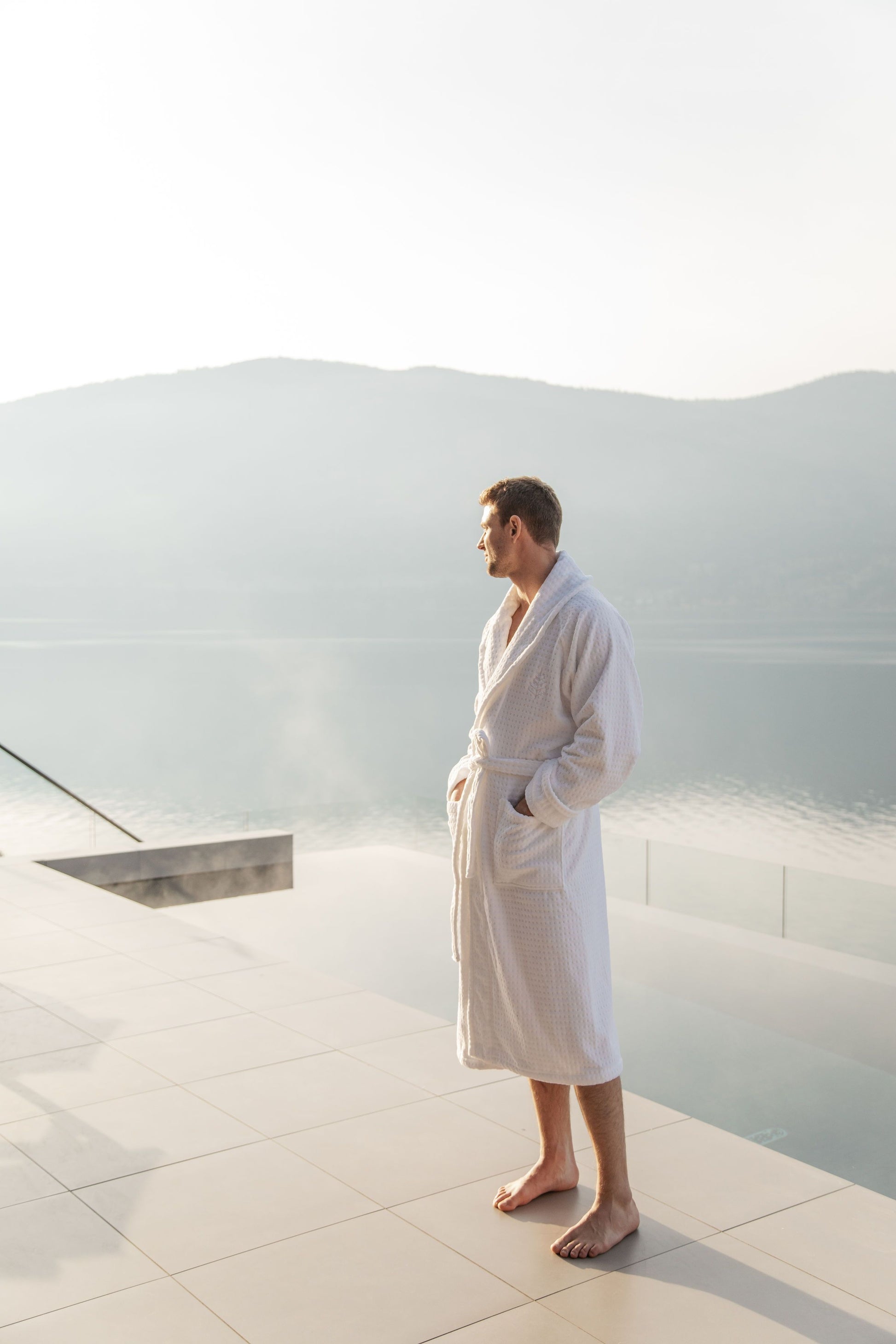 A man outdoors wearing a bathrobe that exudes softness and comfort.