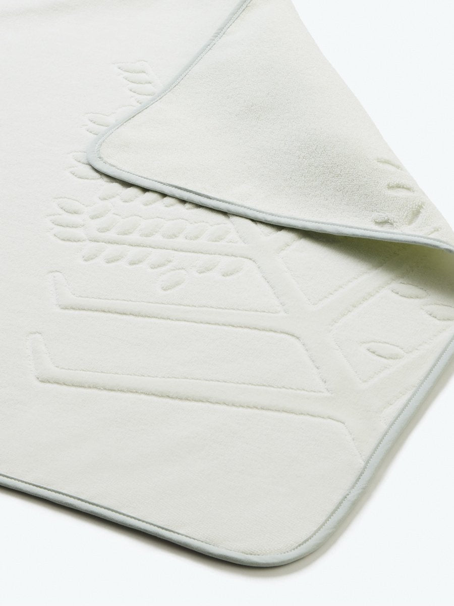 Close-up detail of a "Safari Sage" hooded baby towel with a textured, embroidered Four Seasons logo.
