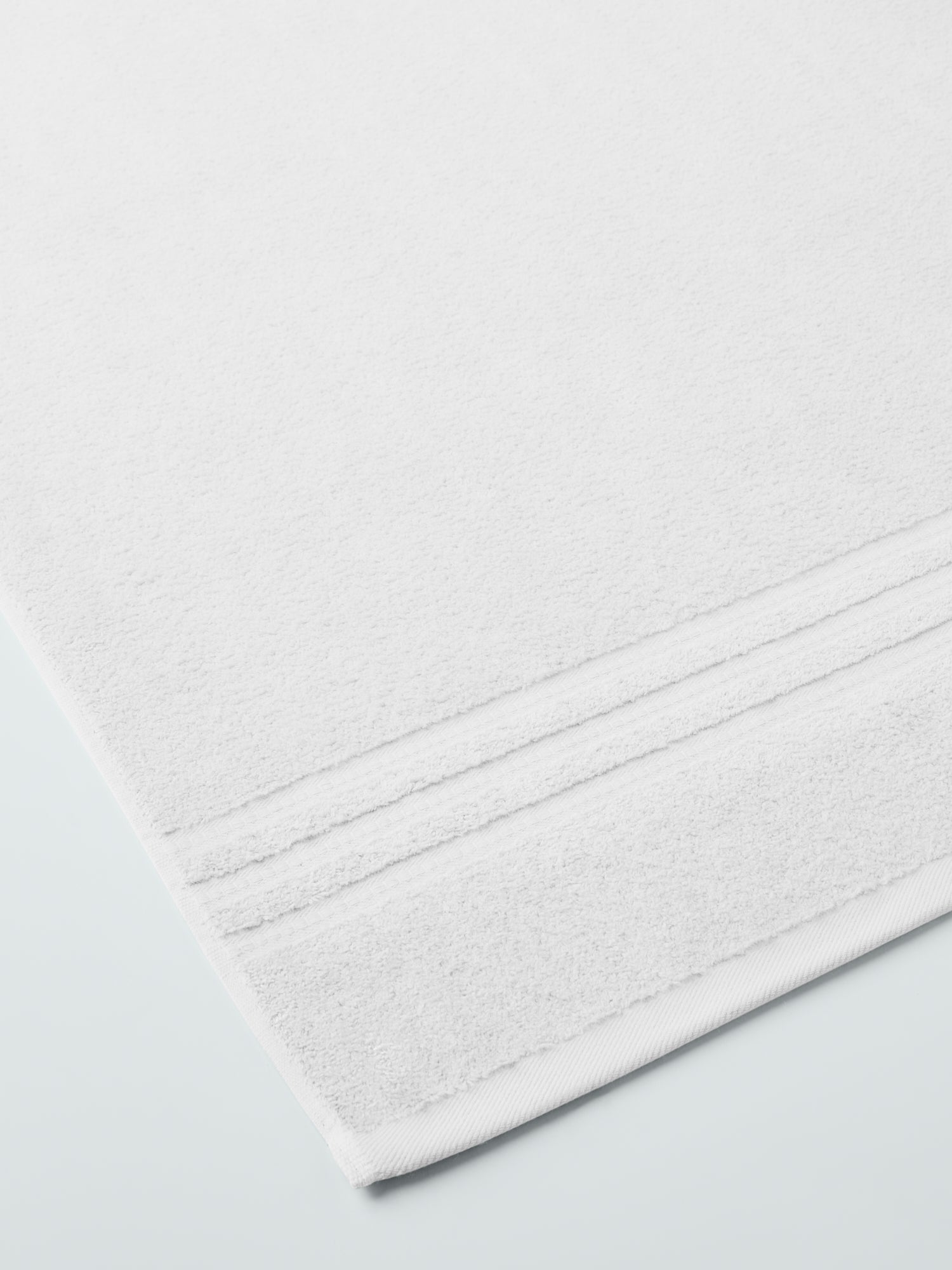 plush, folded bath sheets in a warm, inviting "Signature White" color. The towels have a thick, textured weave and subtle stripes
