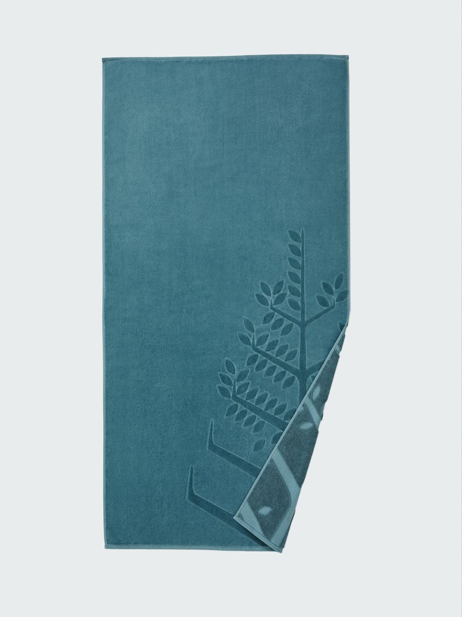 'Polynesian Lagoon' beach towel with an embossed Four Seasons logo. Part of the towel is folded back to reveal the same design on the bottom.