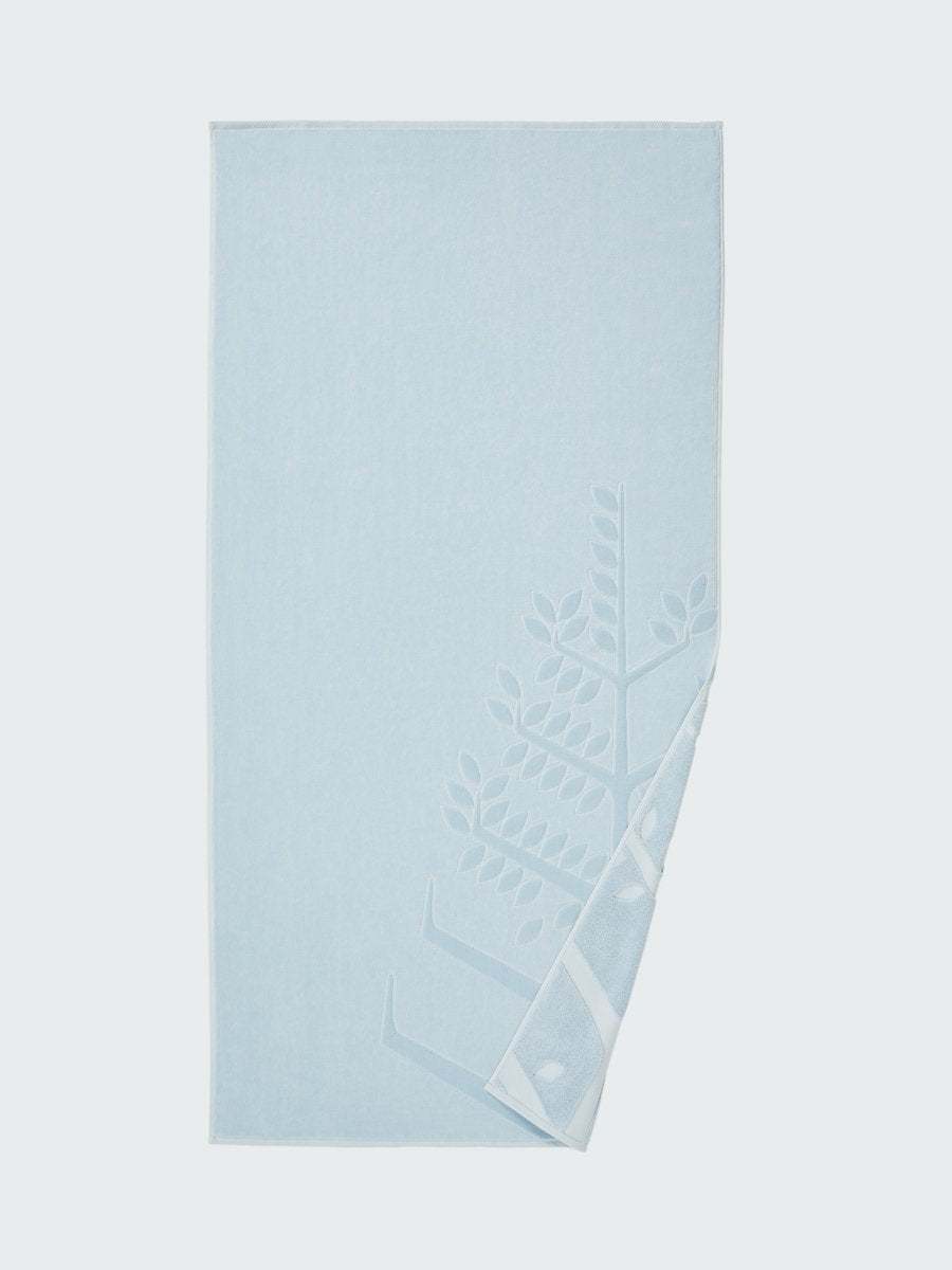 'Maldivian Atoll' beach towel with an embossed Four Seasons logo. Part of the towel is folded back to reveal the same design on the bottom.