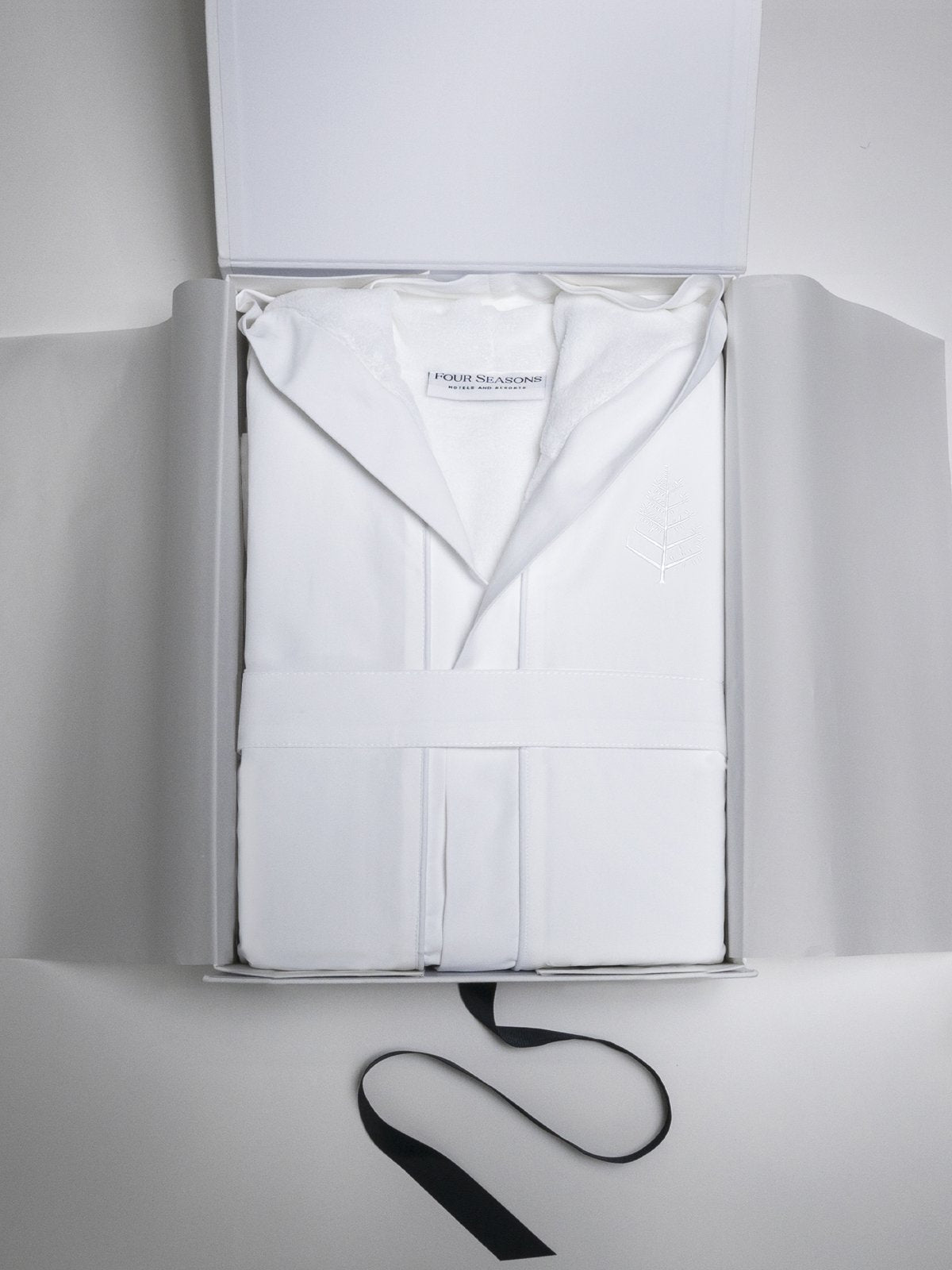 A sleek white cardboard box, which opens to reveal the children's robe inside.