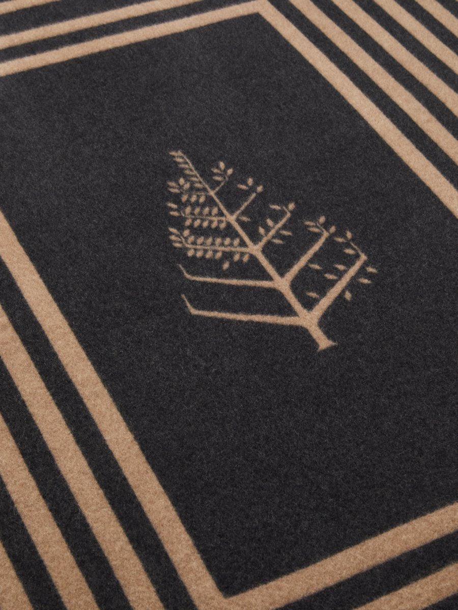 Close-up of a black throw with Iconic jacquard woven Four Seasons logo