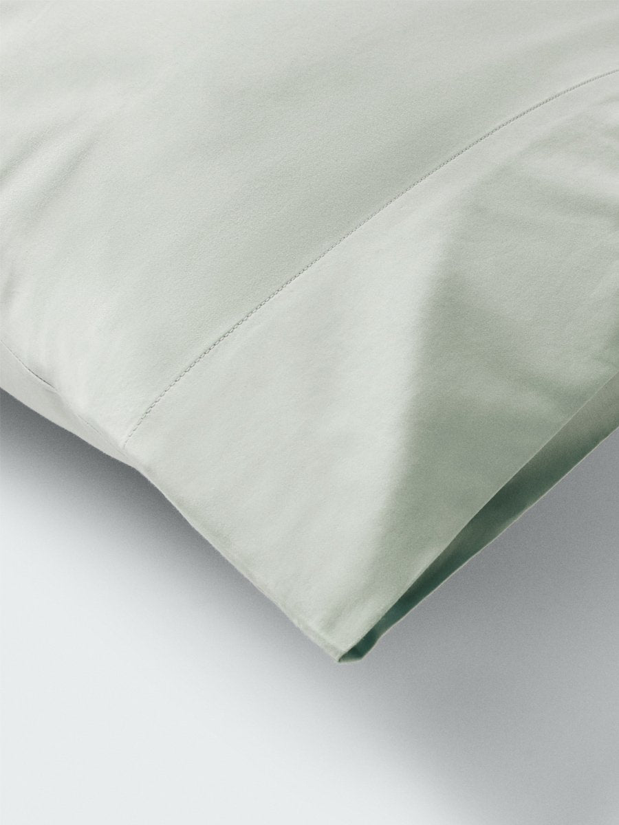 Part of a pillow with a pillowcase in Florentine Sage color.