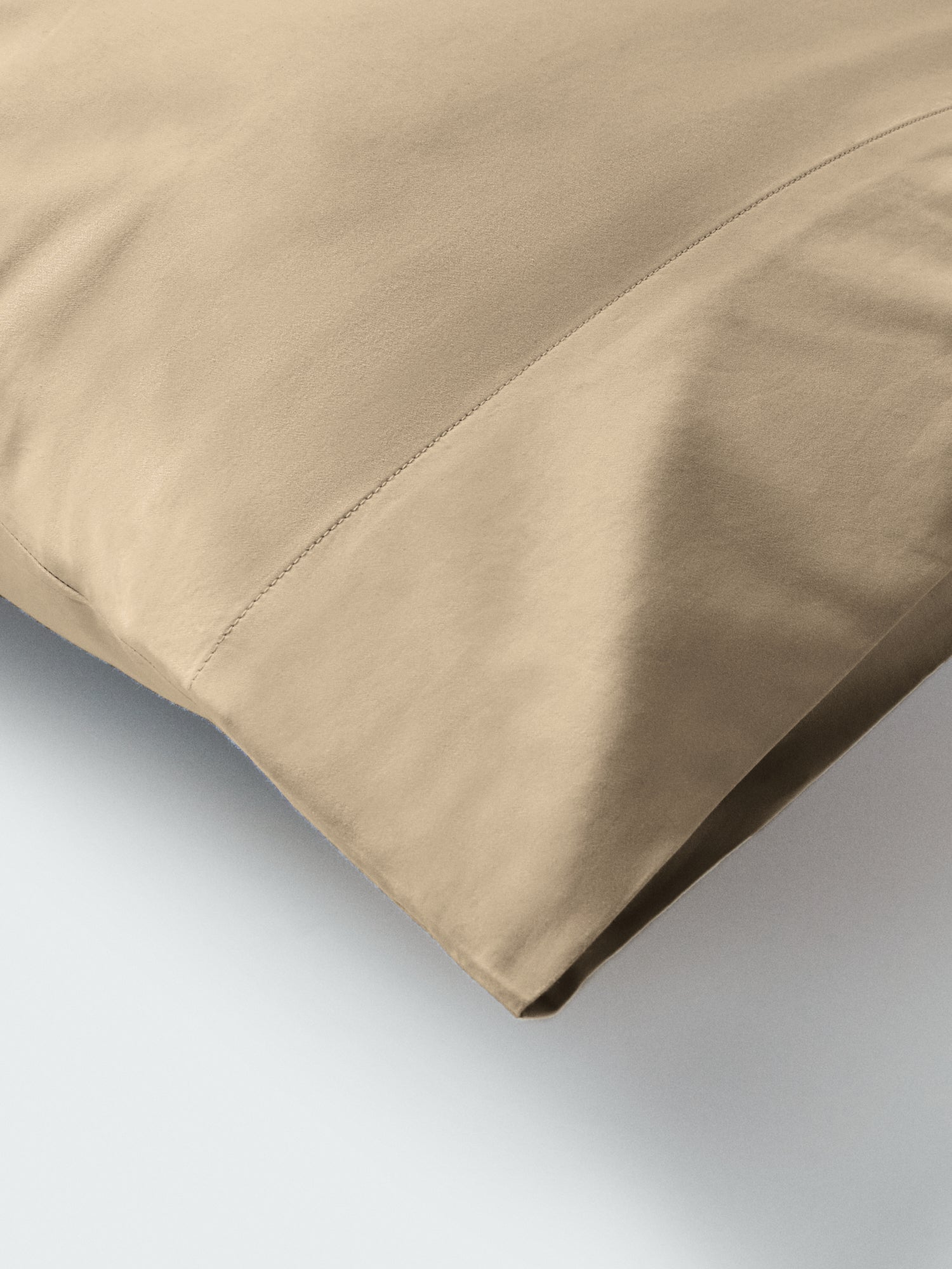 Part of a pillow with a pillowcase in Egyptian Camel color.