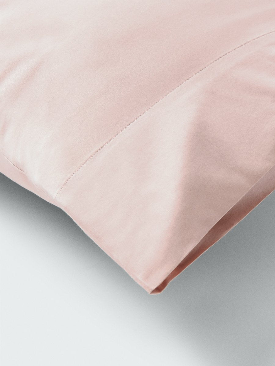 Part of a pillow with a pillowcase in Kyoto Blush color.