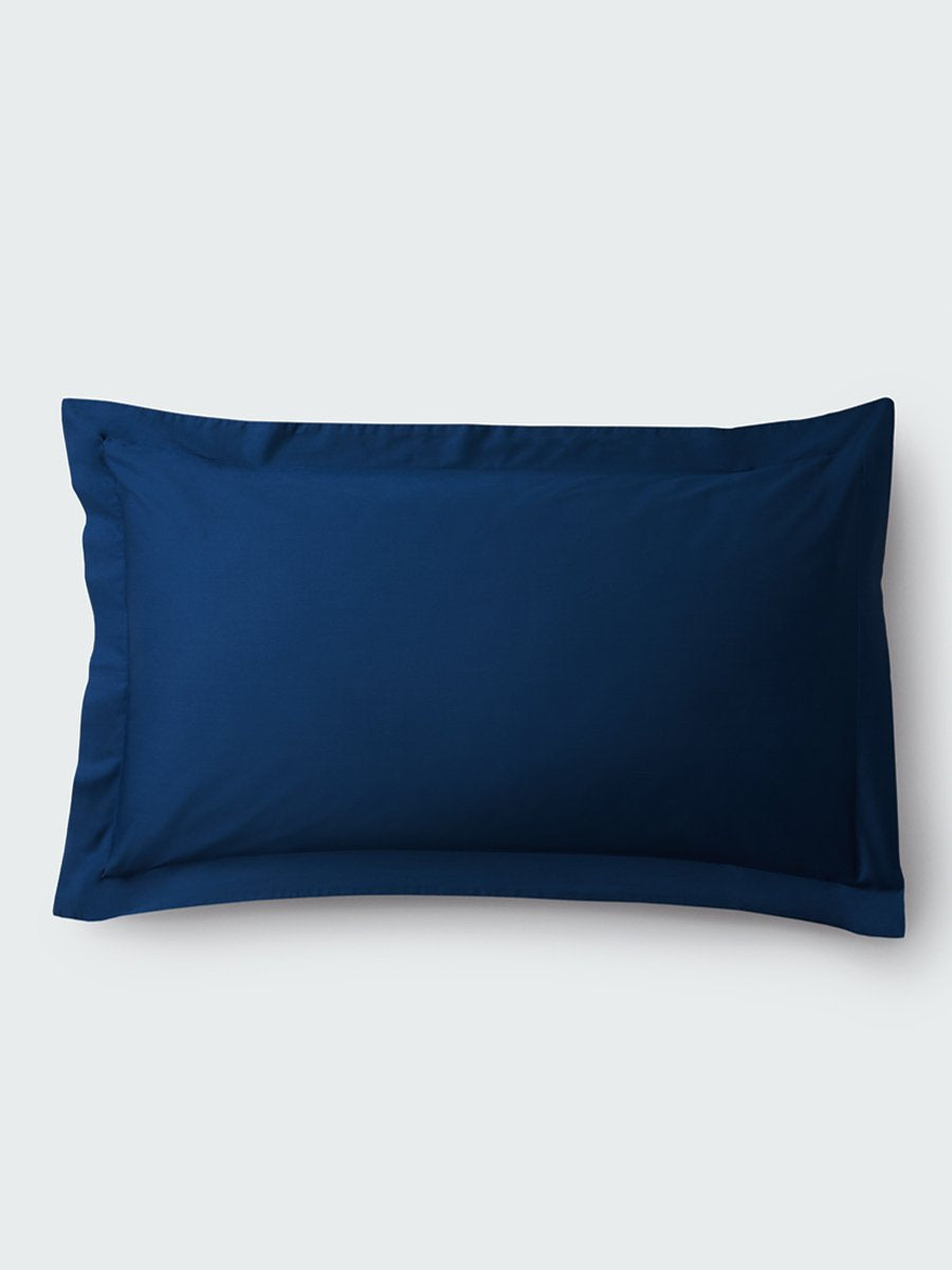 A rectangular pillow with a Riviera Navy color pillowcase, featuring a delicate embroidery that runs along the entire edge.