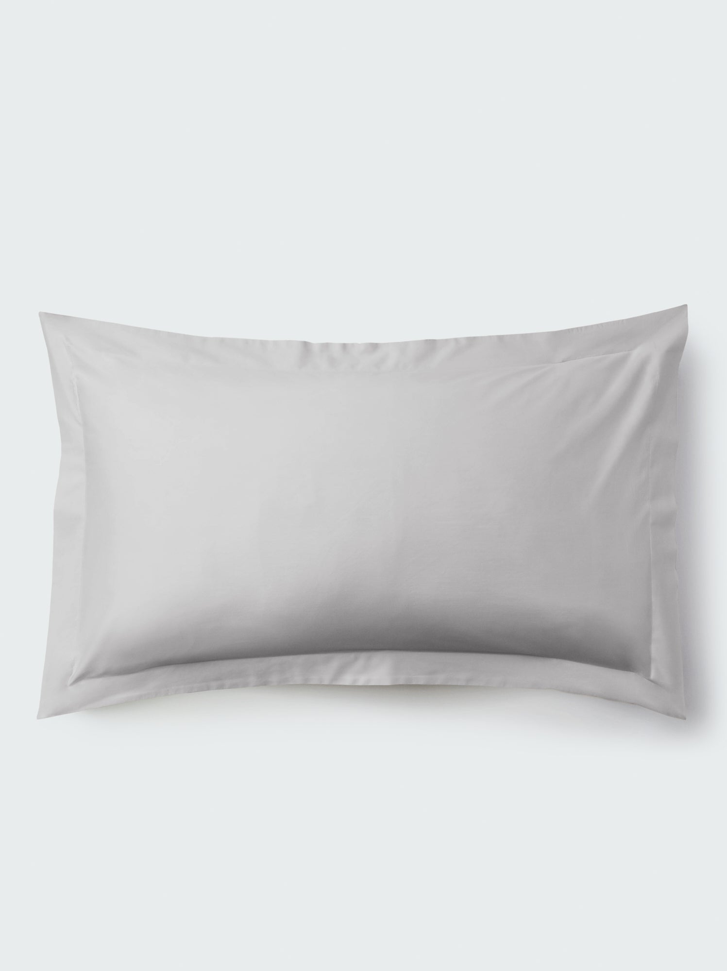 A rectangular pillow with a Turkish Silver color pillowcase, featuring a delicate embroidery that runs along the entire edge.