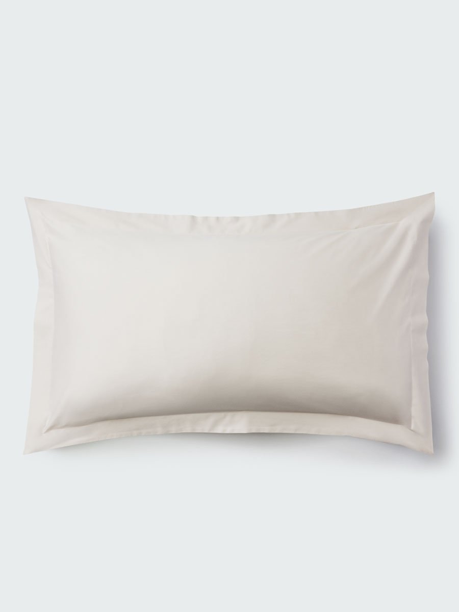 A rectangular pillow with a Balinese Pearl color pillowcase, featuring a delicate embroidery that runs along the entire edge.