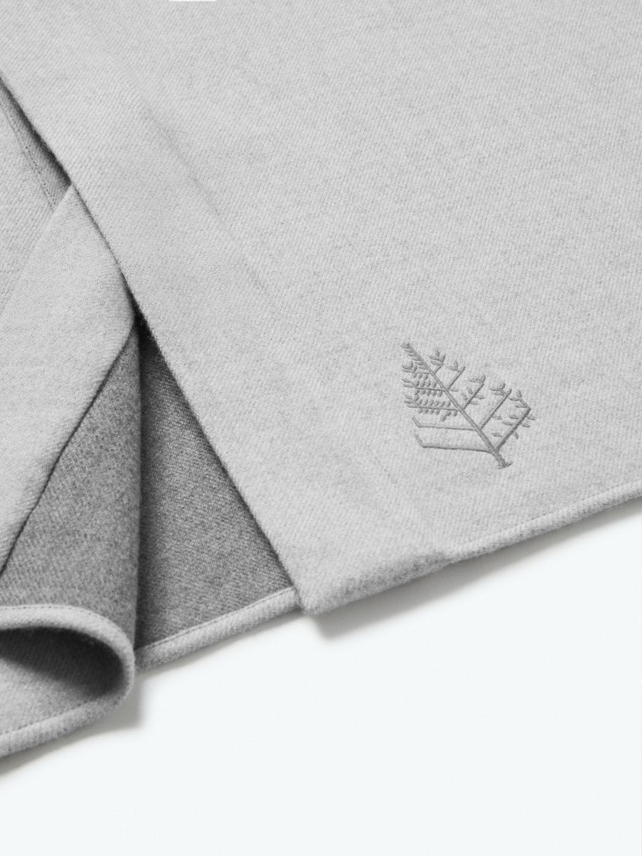 The exterior of the robe showcases a soft and uniform gray tone, while the interior lining is white, creating a pleasing visual contrast.