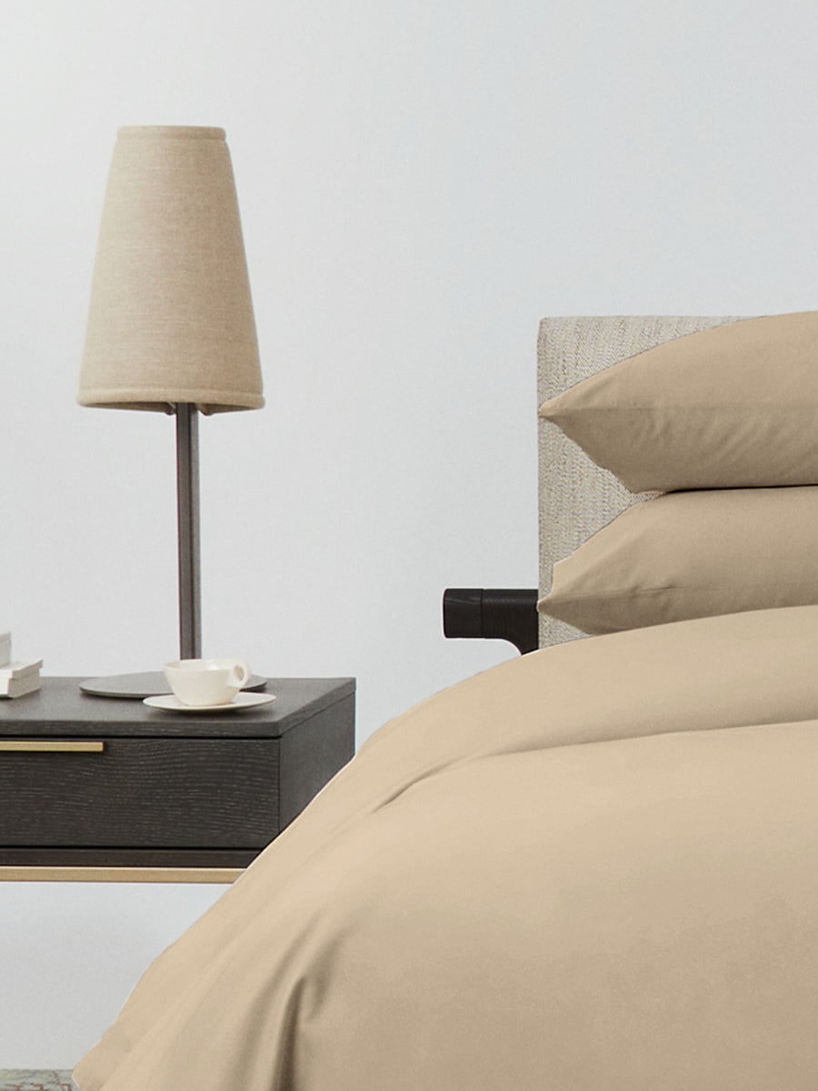 Bed dressed with a duvet in Egyptian Camel color and two matching pillows.