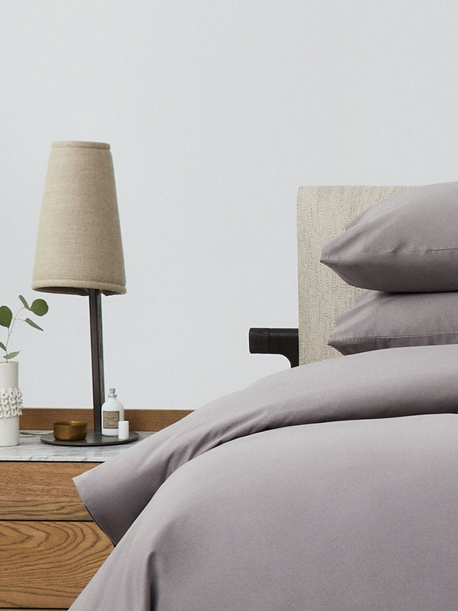 Bed dressed with a duvet in 'Hampshire Charcoal' color and two matching pillows.