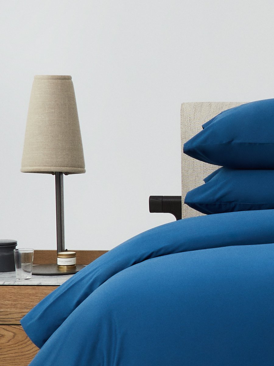 Bed dressed with a duvet in Riviera Navy color and two matching pillows.