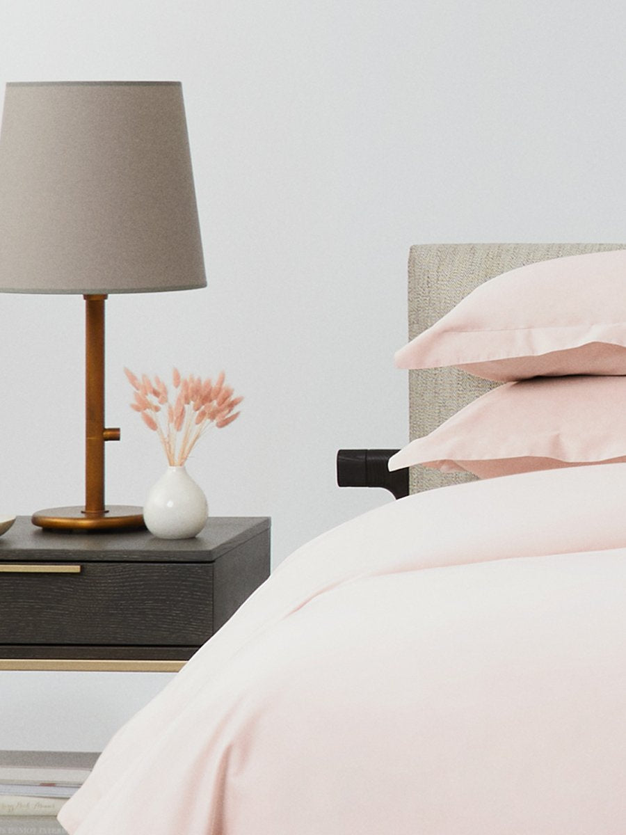A rectangular pillow with a Kyoto Blush color pillowcase, featuring a delicate embroidery that runs along the entire edge.