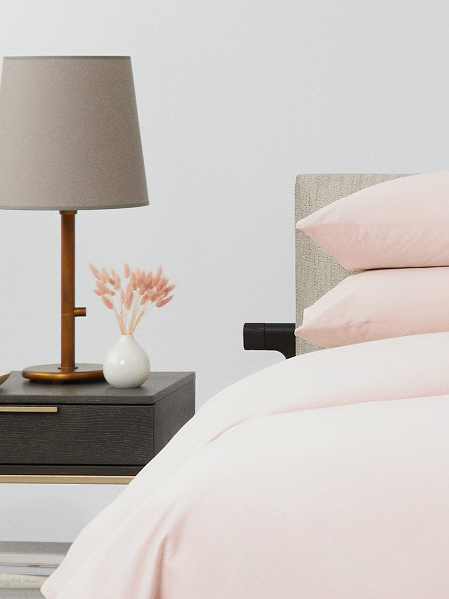 Bed dressed with a duvet in Kyoto Blush color and two matching pillows.
