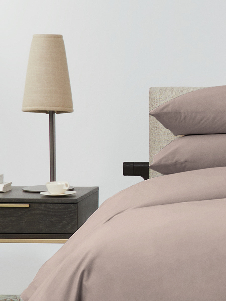 Bed dressed with a duvet in Moroccan Sand color and two matching pillows.