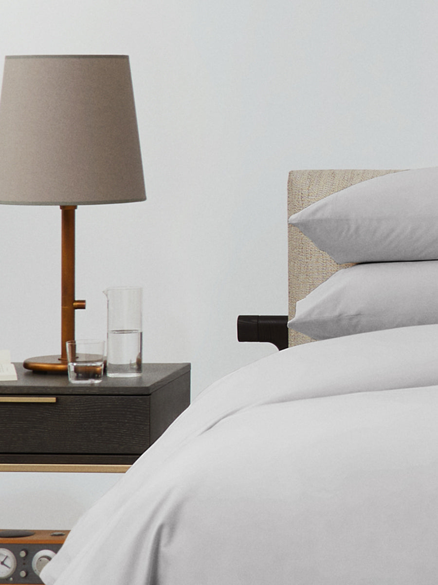 Bed dressed with a duvet in Turkish Silver color and two matching pillows.