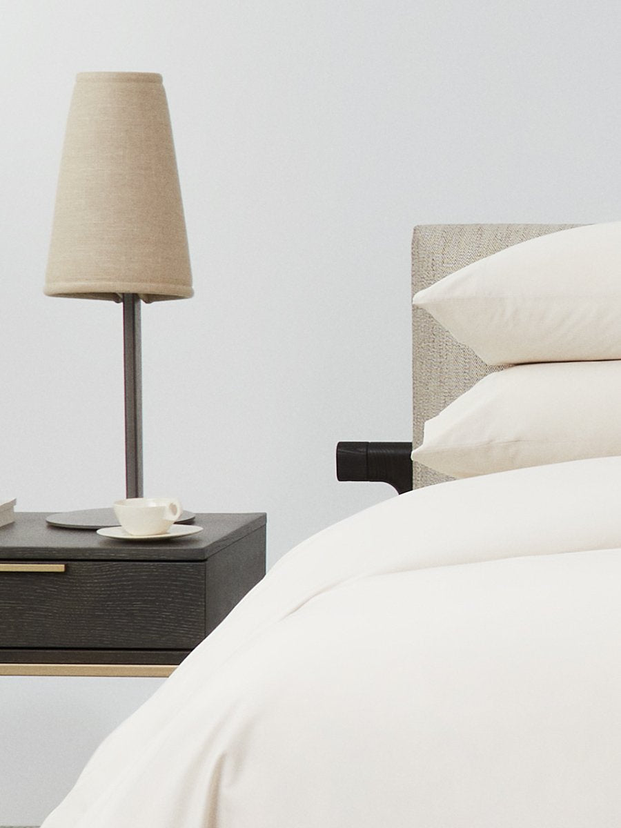 Bed dressed with a duvet in Balinese Pearl color and two matching pillows.