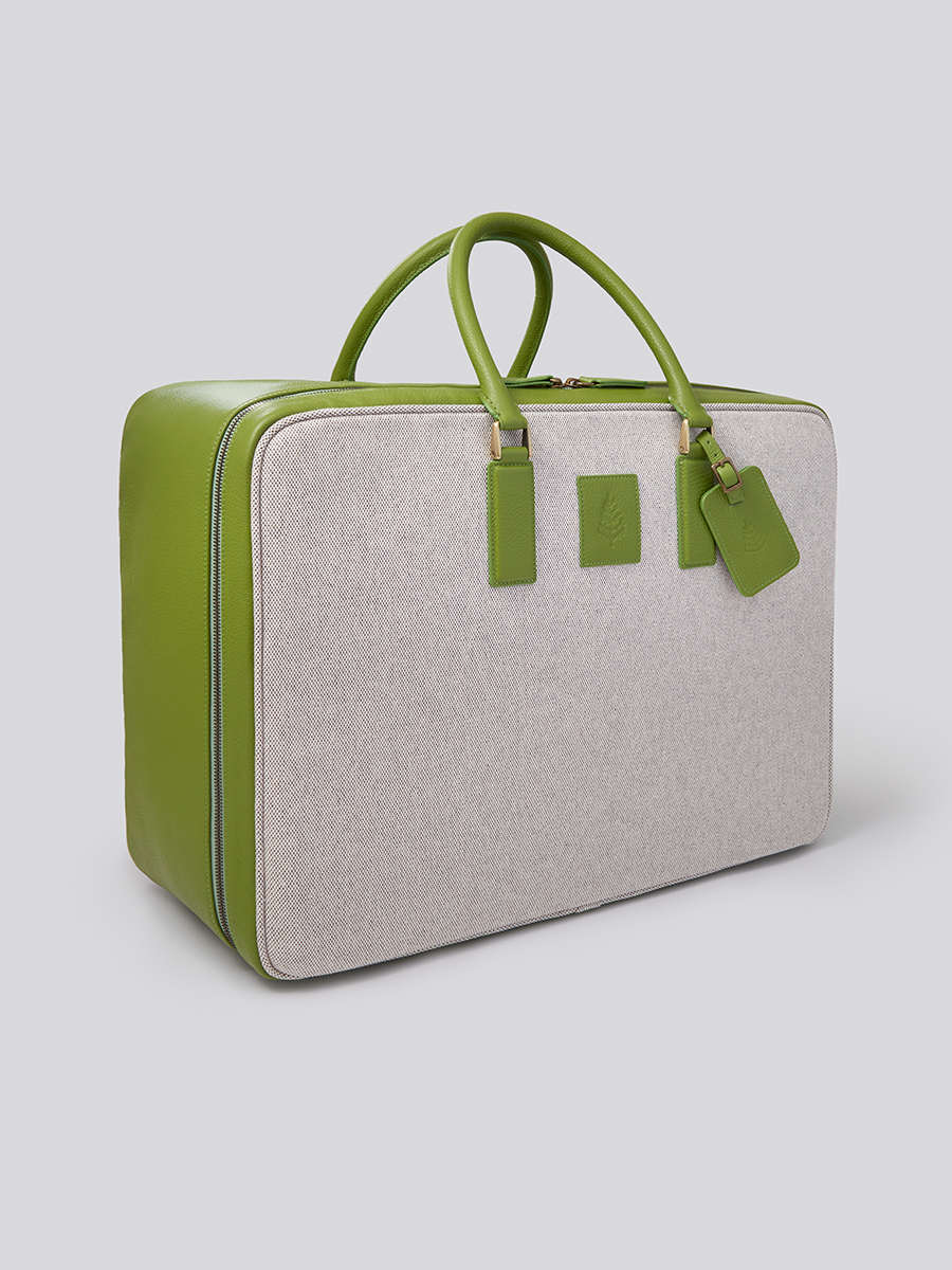 The Valisette travel bag in a vibrant Kyoto Matcha green, crafted from Italian Pebble Grain Leather and Organic Cotton Toile, is a stylish and sophisticated travel companion.