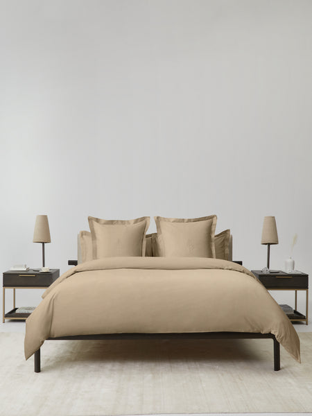 Bed dressed with a duvet and soft pillows, inviting a restful sleep in a serene and sophisticated environment.