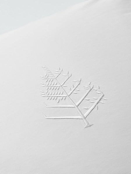 Detail of an embroidery with the store logo on a sheet.