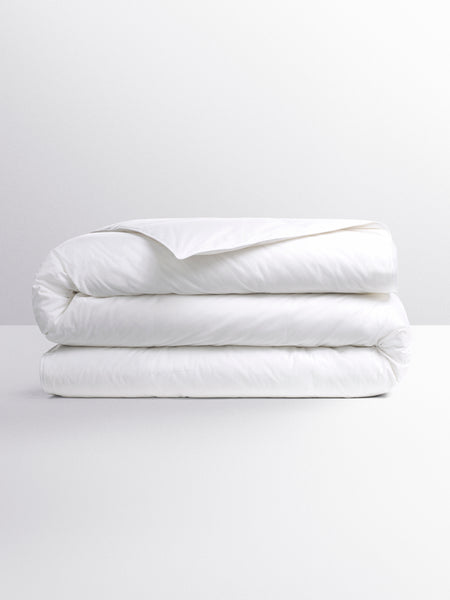 White duvet folded into three parts. Its design suggests a versatile duvet, suitable for various temperatures.