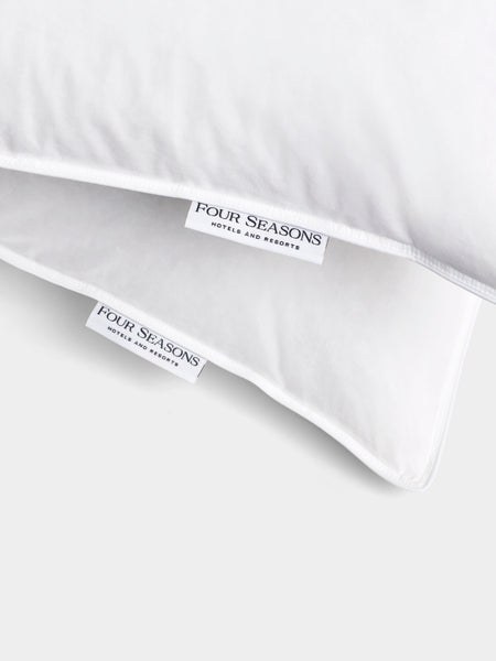 Two white labels sewn into a duvet cover. Both labels feature the Four Seasons Hotels and Resorts logo.