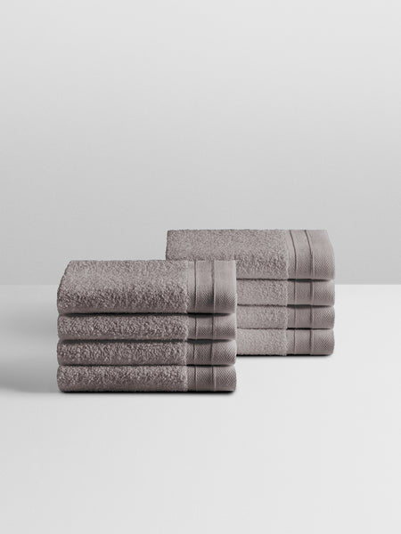 A stack of eight soft, “Hampshire Charcoal” colored bath wash clothes neatly folded on a white surface.