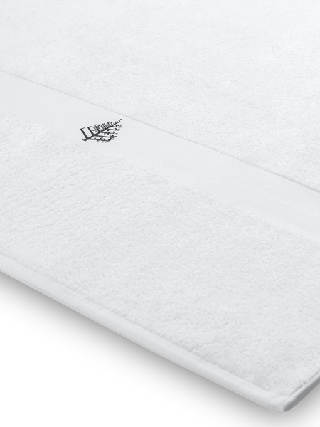 Close-up of a white Four Seasons pool towel with an embroidered Four Seasons logo.