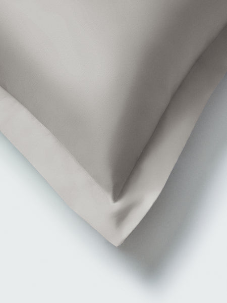 Part of a pillow with a Spanish Slate color pillowcase featuring embroidery along the edge.