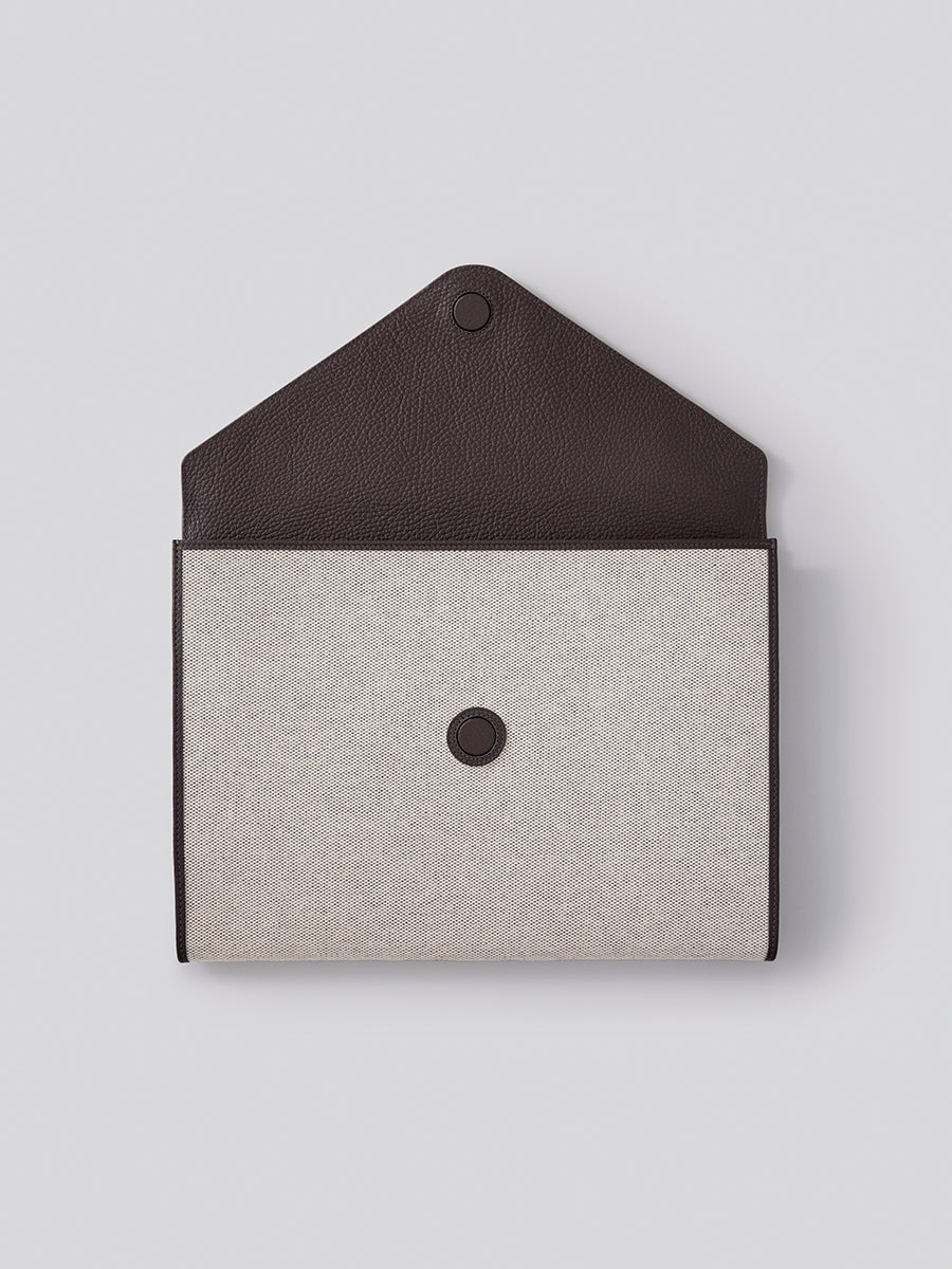 The Laptop Sleeve in Malaysian Cocoa, showcasing its protective interior and luxurious materials like Italian Pebble Grain Leather and Organic Cotton Toile.
