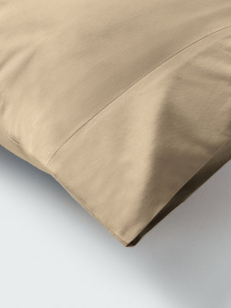 Part of a pillow with a pillowcase in Egyptian Camel color.