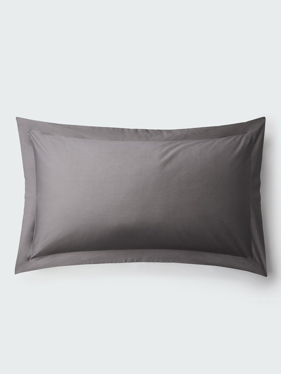 A rectangular pillow with a Hampshire Charcoal color pillowcase, featuring a delicate embroidery that runs along the entire edge.
