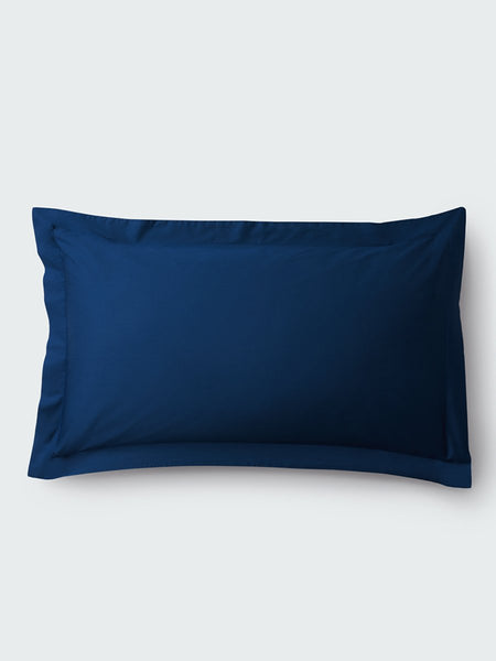 A rectangular pillow with a Riviera Navy color pillowcase, featuring a delicate embroidery that runs along the entire edge.
