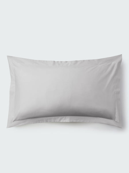 A rectangular pillow with a Turkish Silver color pillowcase, featuring a delicate embroidery that runs along the entire edge.