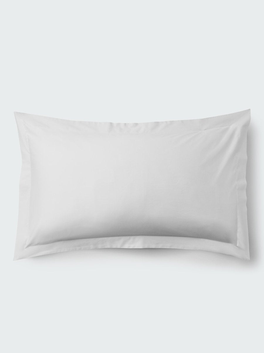 A rectangular pillow with a Signature White color pillowcase, featuring a delicate embroidery that runs along the entire edge.