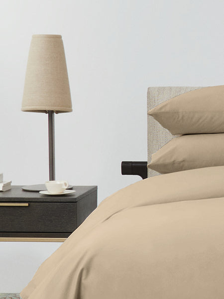 Bed dressed with a duvet in Egyptian Camel color and two matching pillows.
