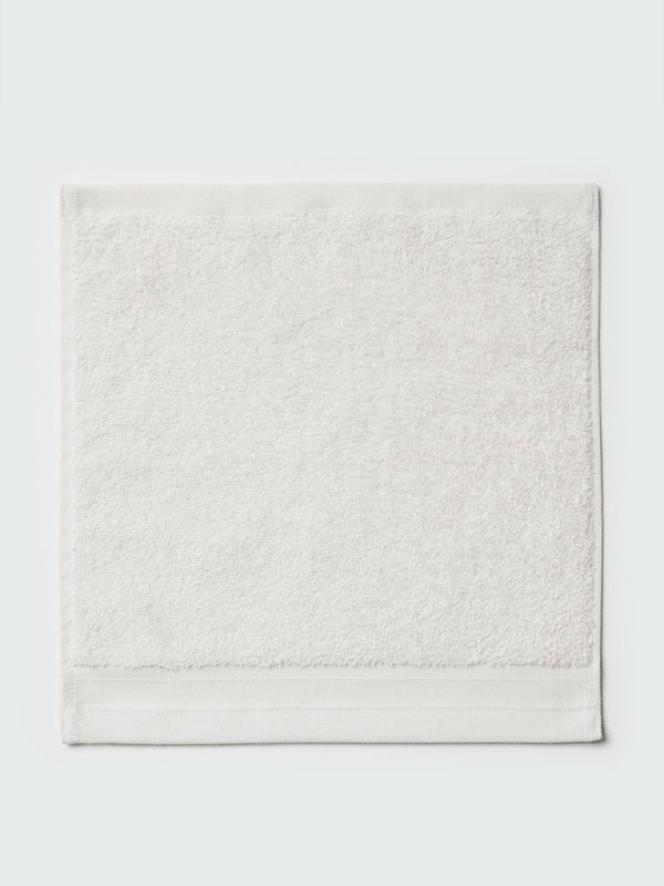 Close-up of a "Signature White"; colored bath wash cloth, visible fabric