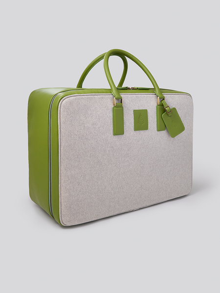 The Valisette travel bag in a vibrant Kyoto Matcha green, crafted from Italian Pebble Grain Leather and Organic Cotton Toile, is a stylish and sophisticated travel companion.